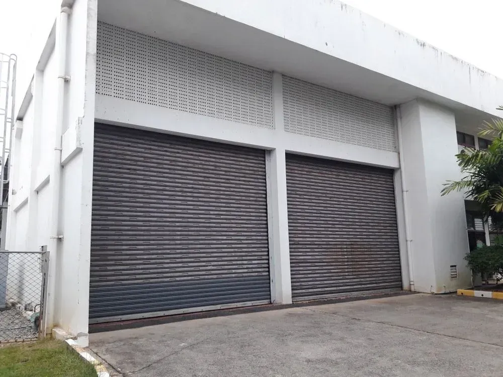 A Large White Building With A Lot Of Garage Doors — Spring Crest Blinds, Awnings & Security Doors in Golden Square, VIC