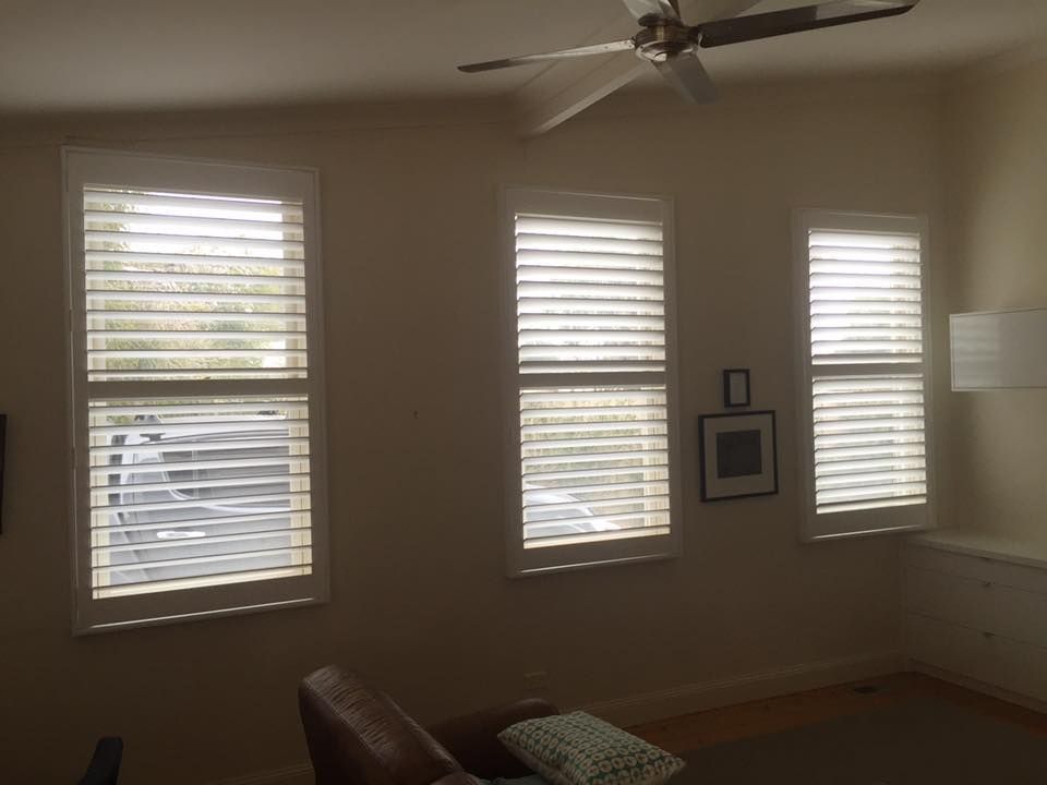 A Living Room With Three Windows And A Ceiling Fan — Spring Crest Blinds, Awnings & Security Doors in Golden Square, VIC