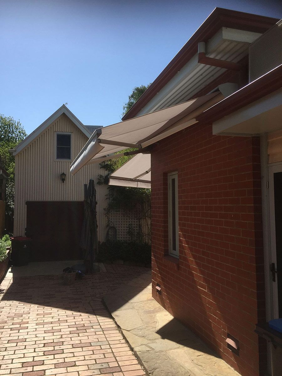 A Brick House With An Awning On The Side Of It — Spring Crest Blinds, Awnings & Security Doors in Golden Square, VIC