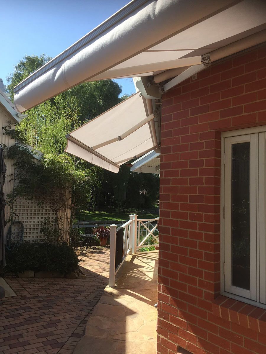 A Brick Building With A White Awning On The Side Of It — Spring Crest Blinds, Awnings & Security Doors in Golden Square, VIC