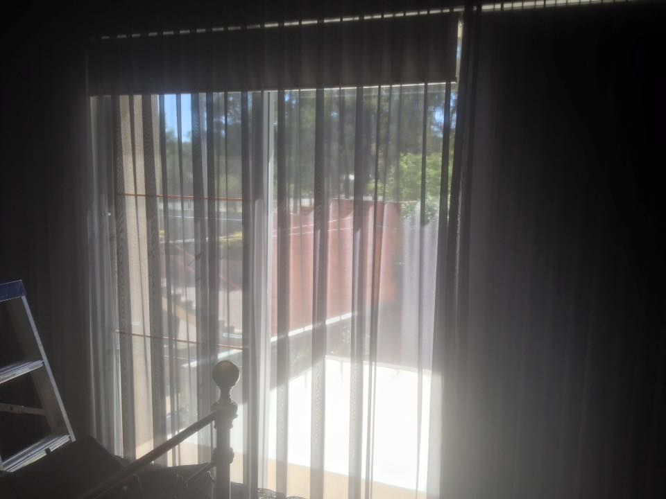The Sun Is Shining Through The Curtains Of A Sliding Glass Door — Spring Crest Blinds, Awnings & Security Doors in Melbourne, VIC