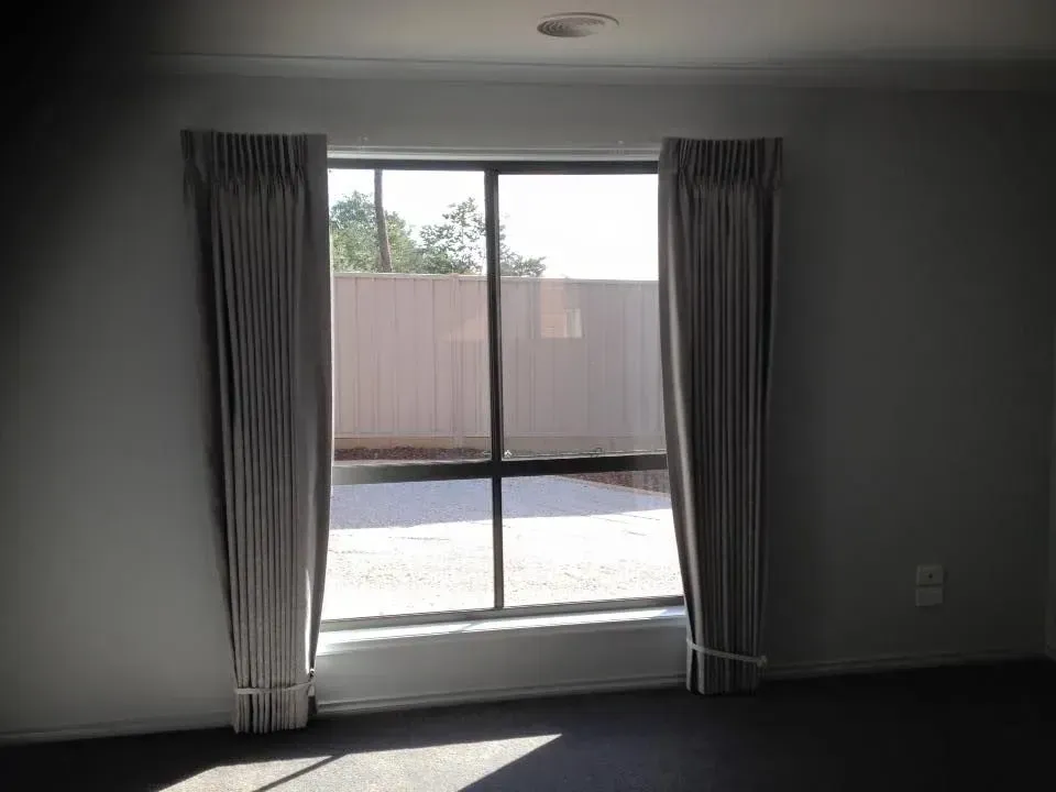 An Empty Room With A Large Window And Curtains — Spring Crest Blinds, Awnings & Security Doors in Golden Square, VIC