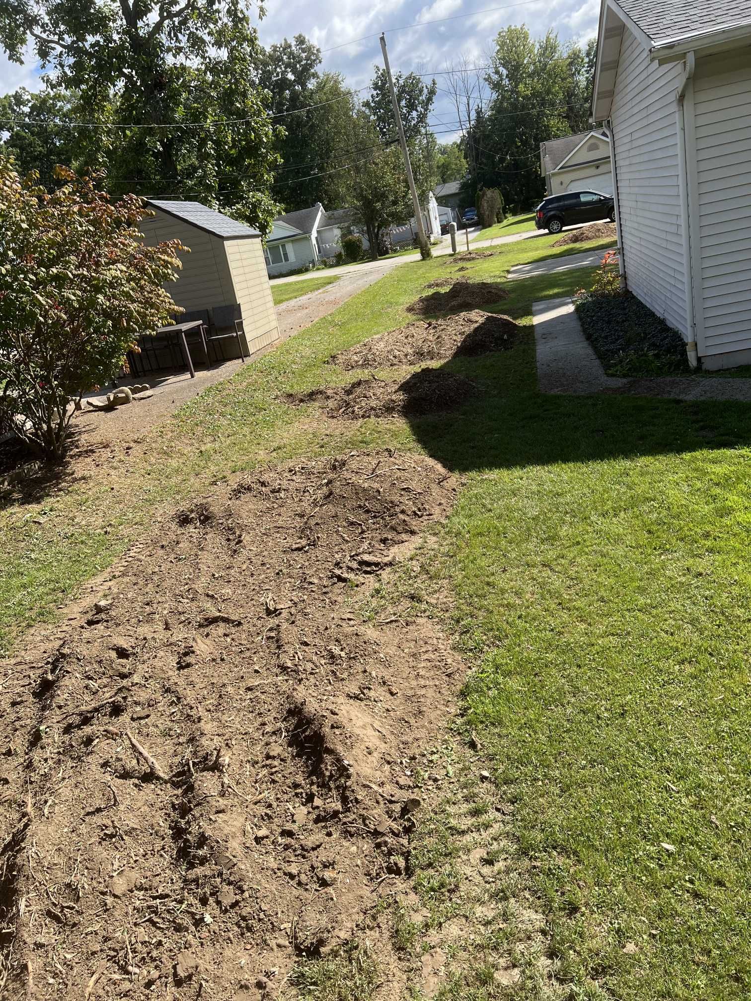 A dirt path leading to a house in a residential neighborhood.