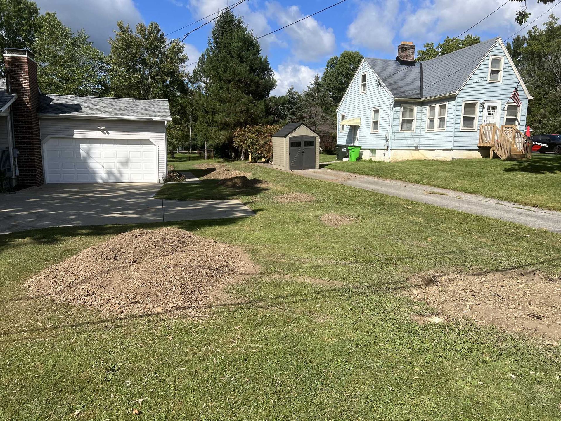 A house with a garage and a shed in front of it.