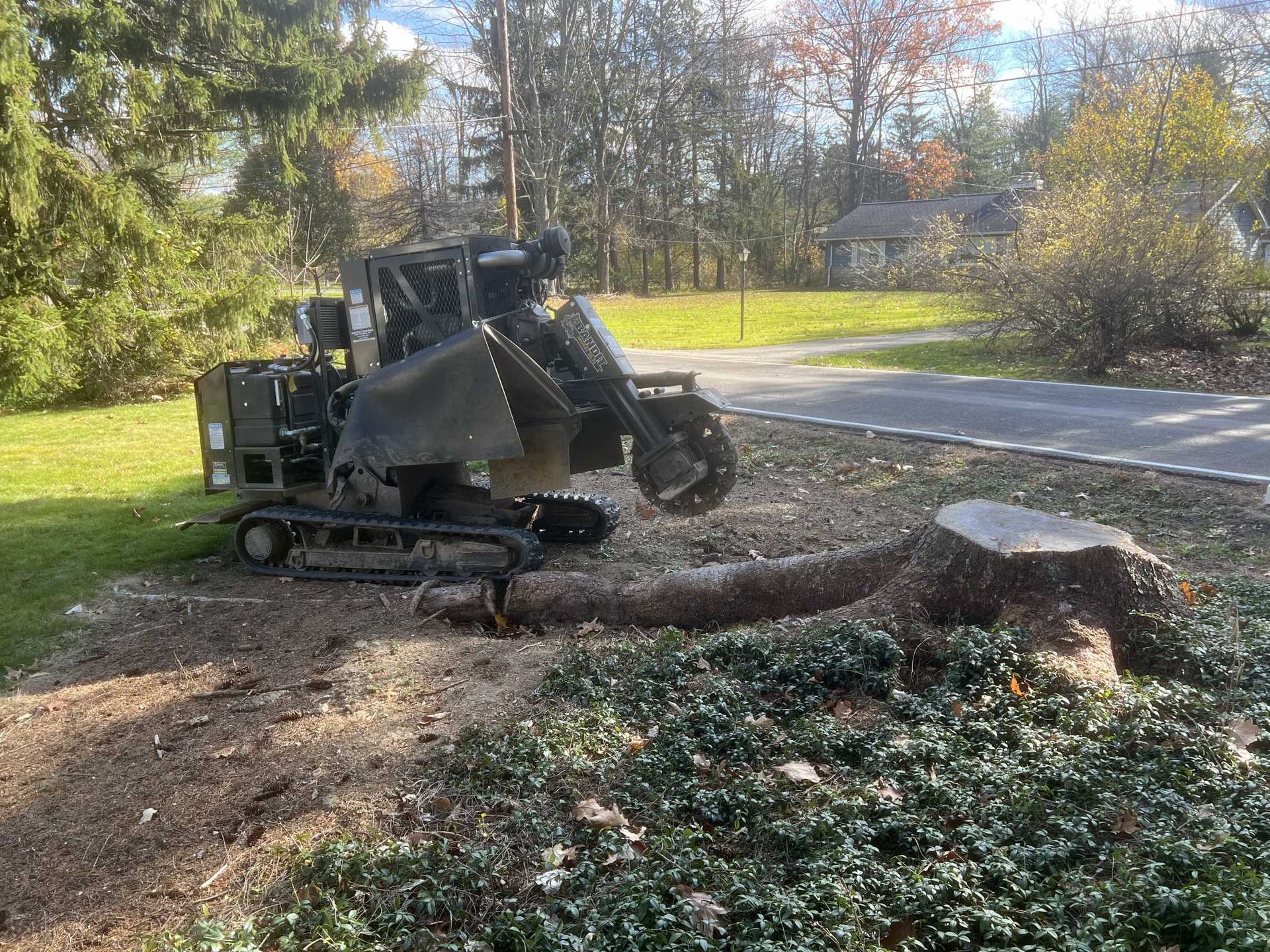 A large tree stump is being removed by a machine.