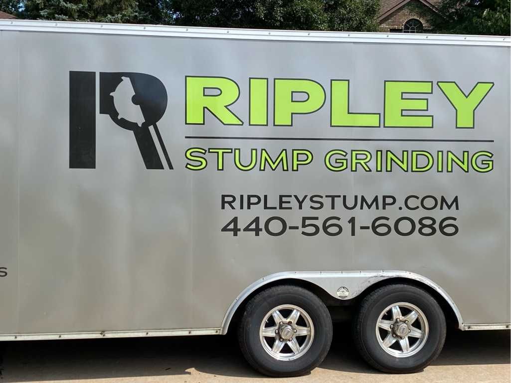 A silver trailer with ripley stump grinding written on it