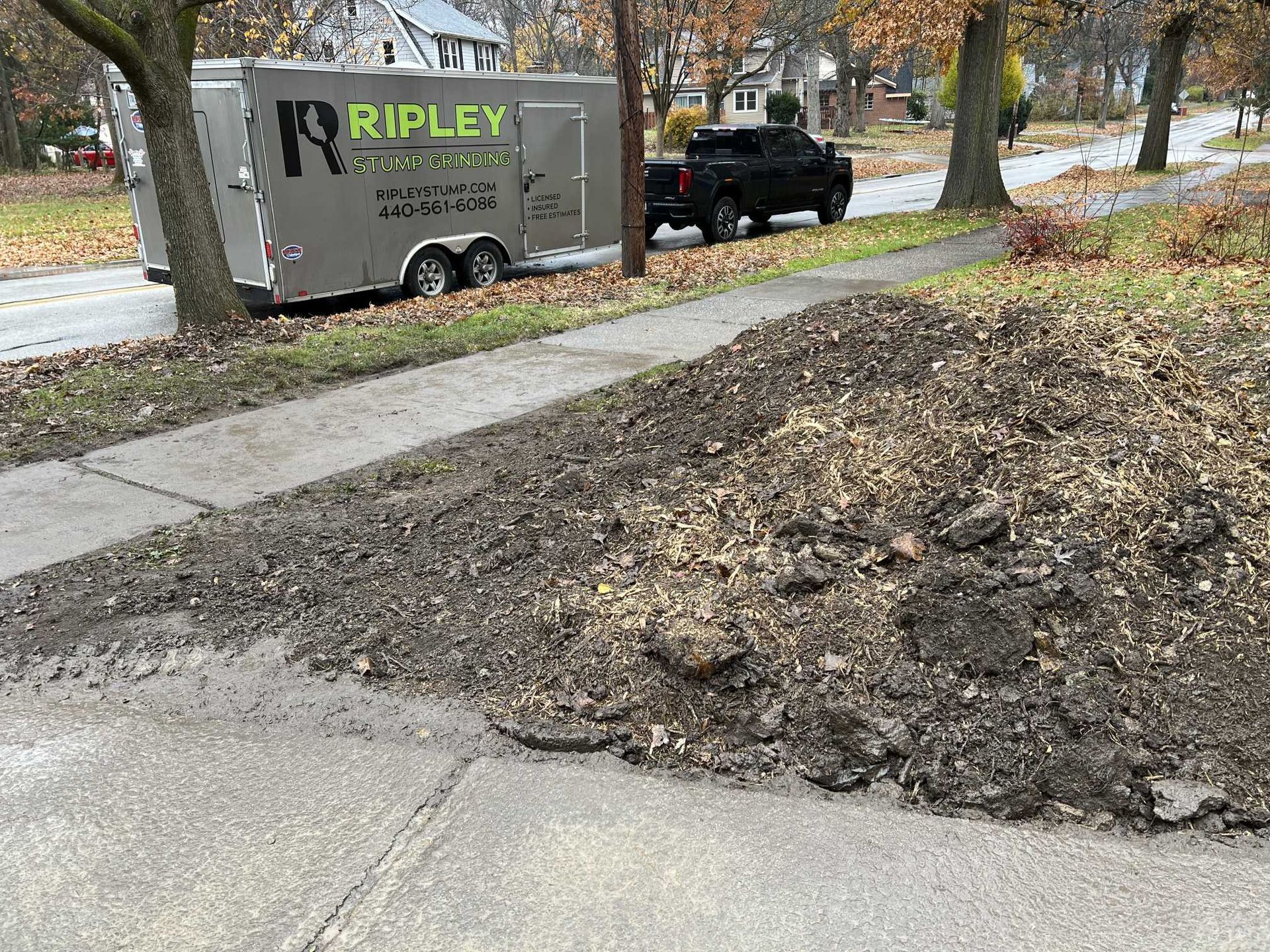 A truck is parked on the side of the road next to a trailer.