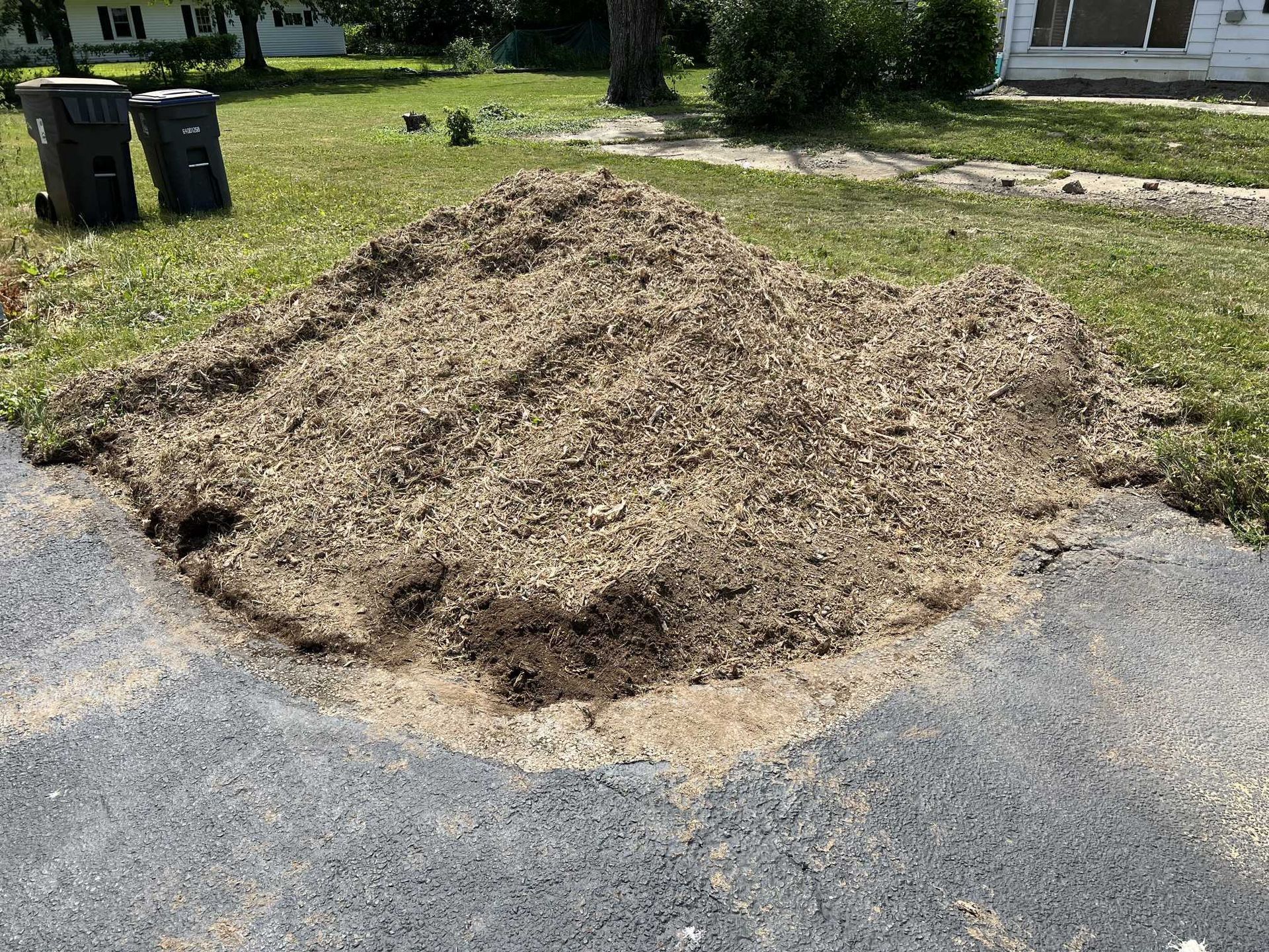 A pile of dirt is sitting on the side of a road.