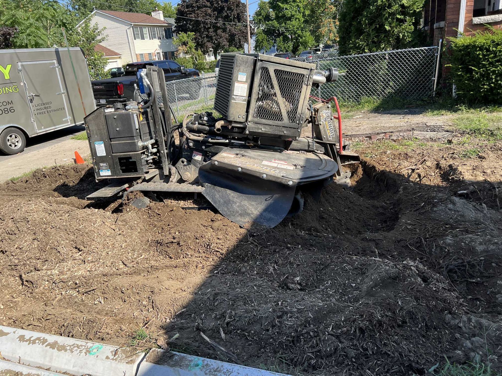A stump grinder is sitting in the middle of a dirt field.