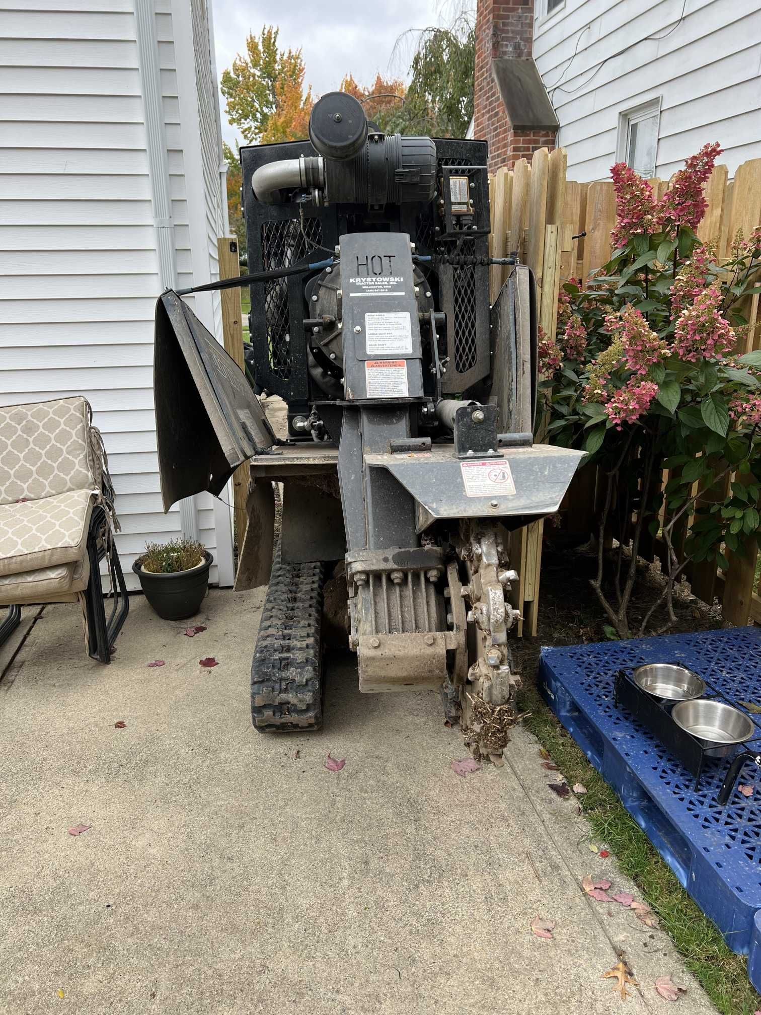 A machine is parked on the side of the road in front of a house.