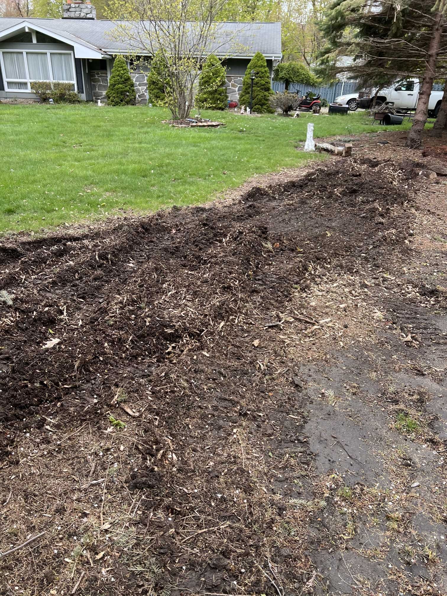 A large pile of dirt is sitting in front of a house.