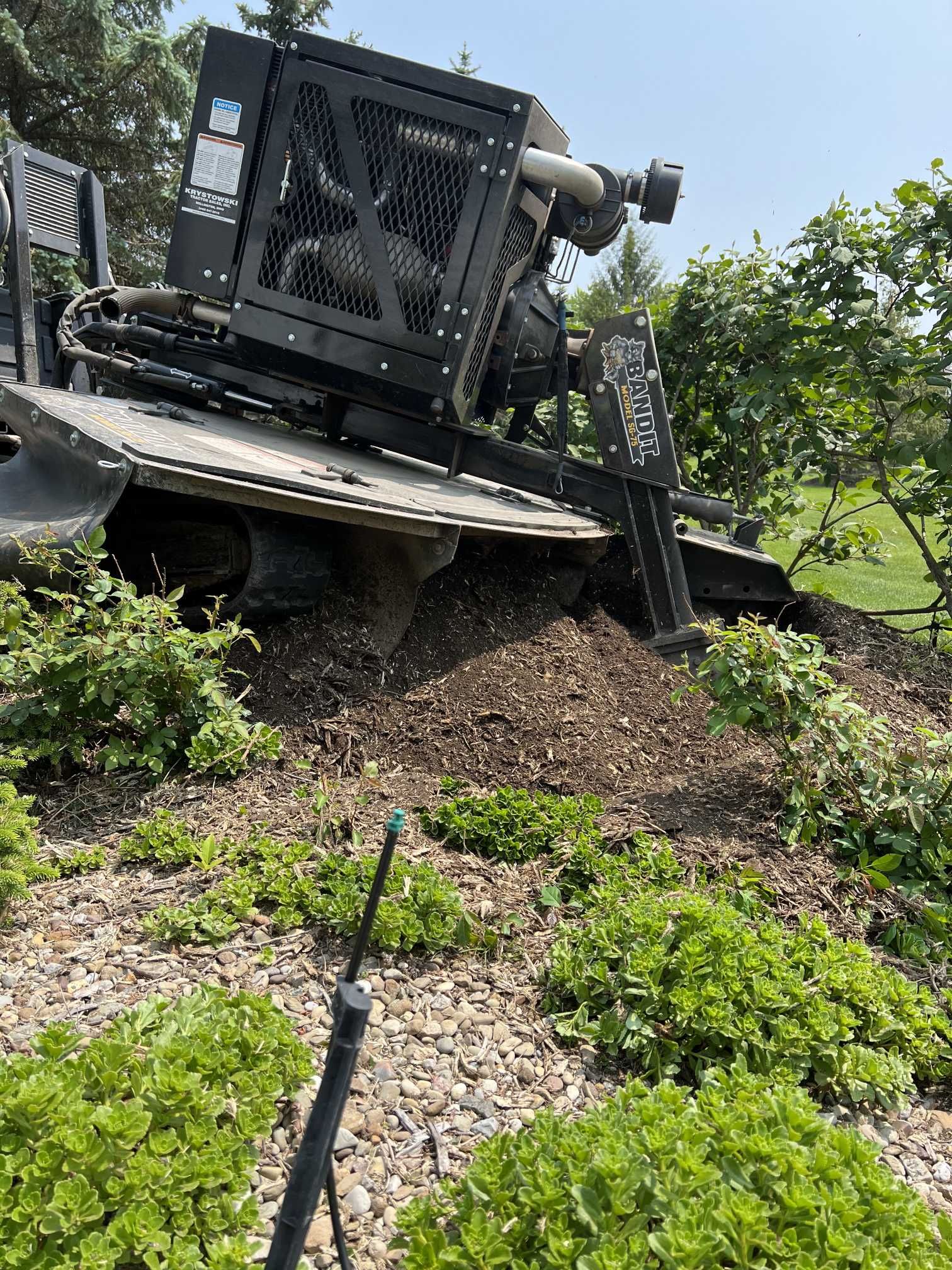 A large machine is sitting on top of a pile of dirt in a field.