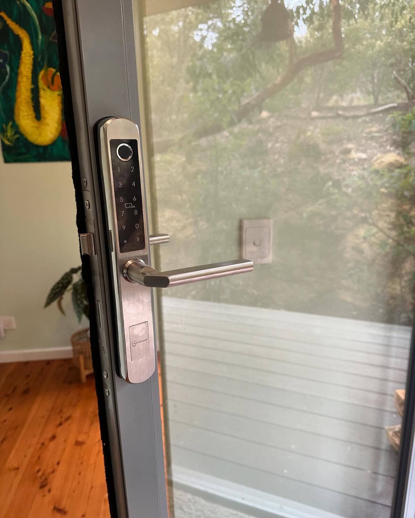 Silver Smart Lock on a Glass Door, With Handle — Great Ocean Locksmiths in Belmont, VIC