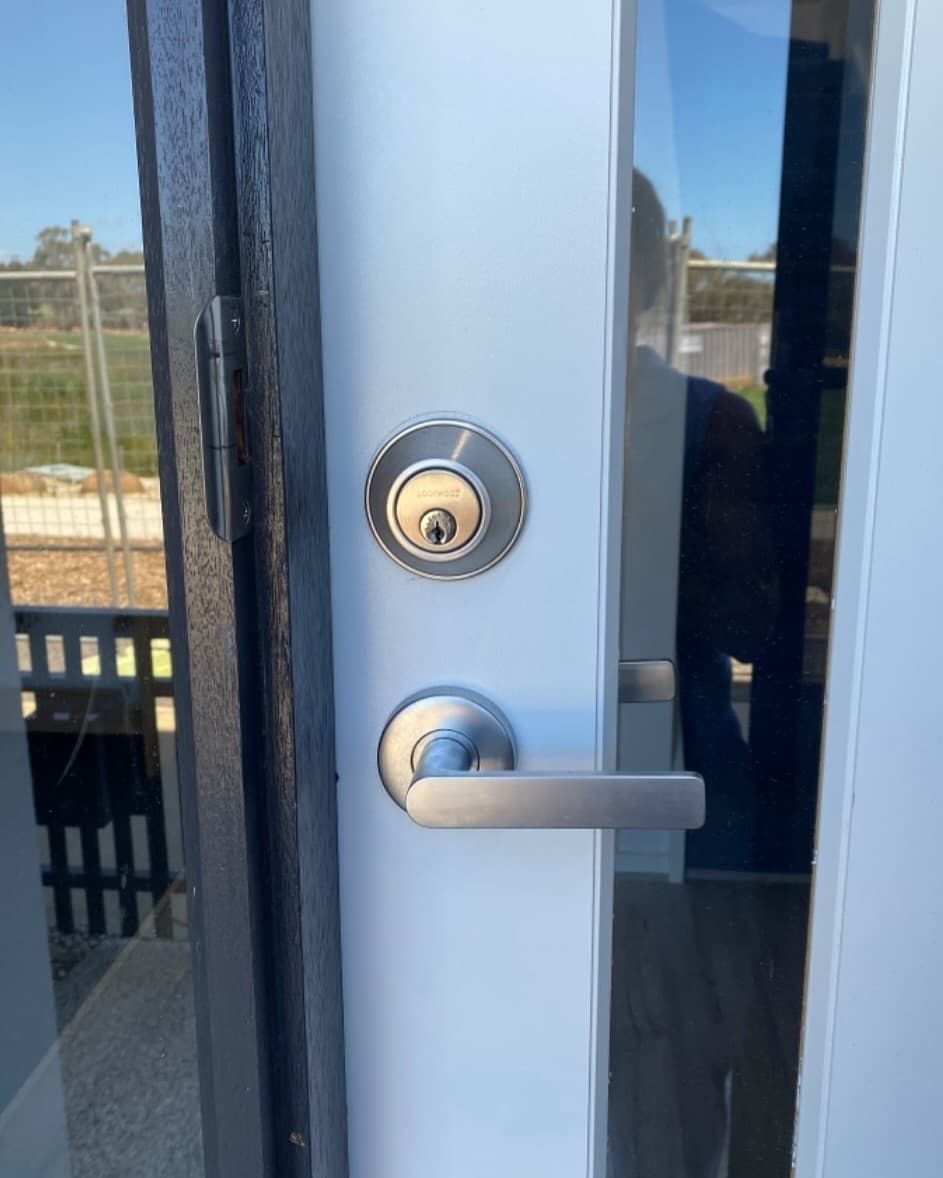 Door With a Lock and Lever Handle on White Frame — Great Ocean Locksmiths in Torquay, VIC