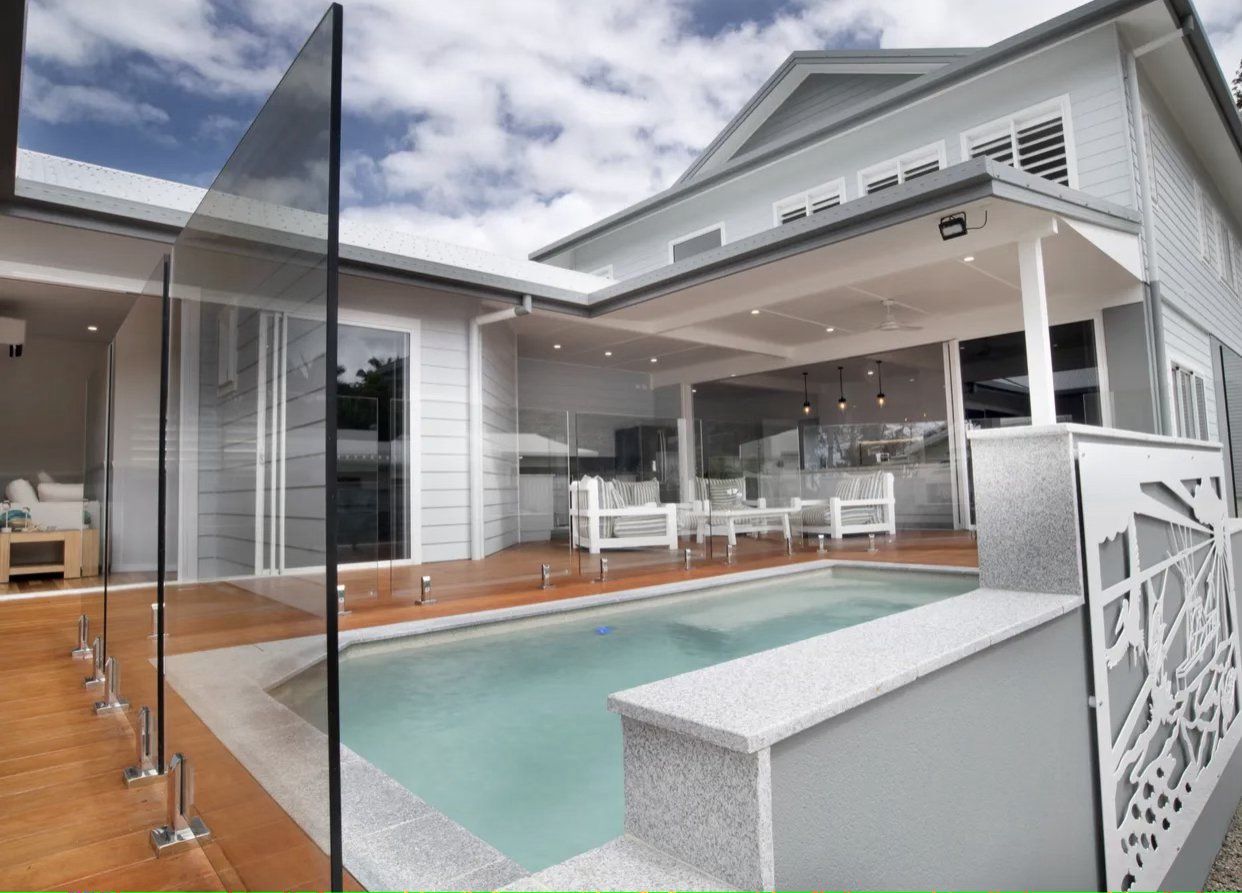 A large white house with a swimming pool in front of it