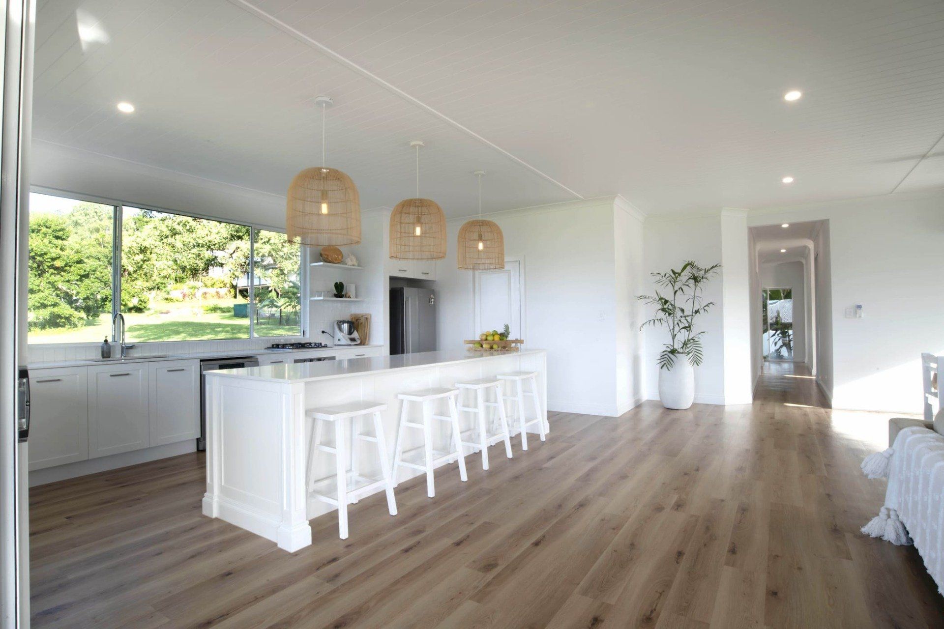 A kitchen with a long island and stools in a house.