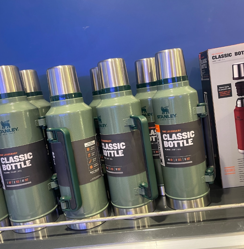 Una fila de botellas clásicas de Stanley están alineadas en un estante.