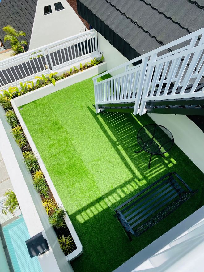 Artificial grass on a home deck with stairs, showcasing an attractive outdoor living area