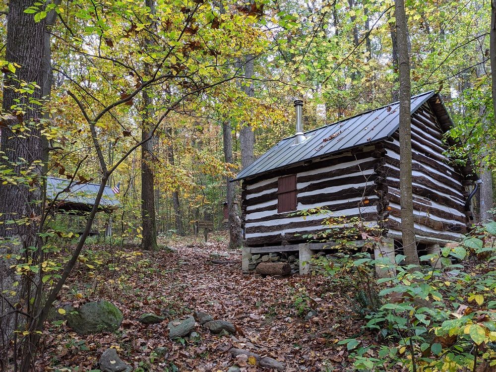 The side view of Bear Spring shelter is surrounded by vegetation and trees.