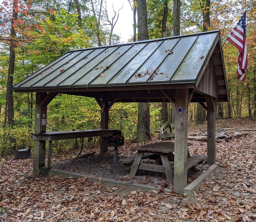 The cook shed at Bear Spring cabin shows a wooden cooking area and a wooden picnic table.
