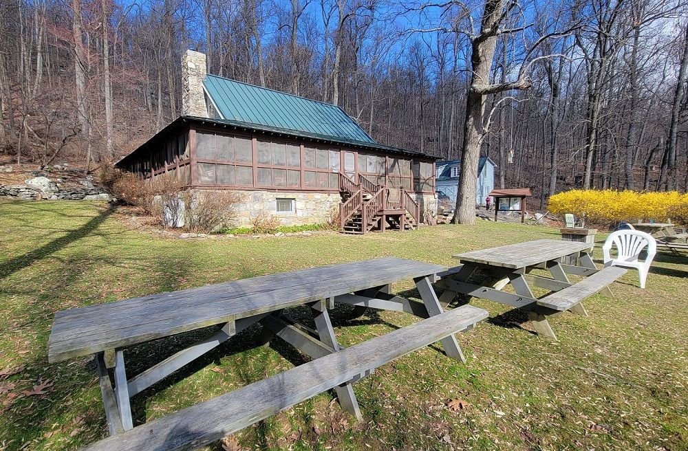 The back view of Blackburn Trail cabin showing a grassy area with wooden picnic tables.
