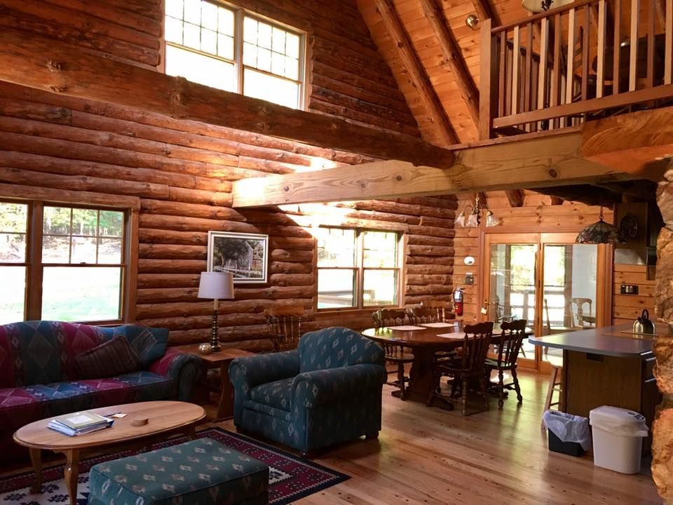 The inside of Catoctin Hollow Lodge shows two levels, one with cloth furniture, a wooden table and chairs, and a small kitchen.