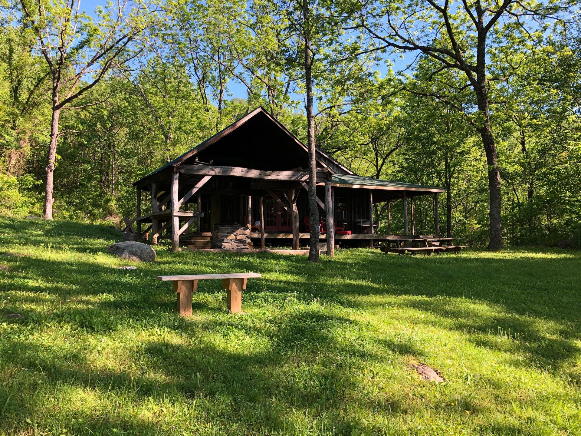 The front view of Conley cabin shows a wooden porch and multiple picnic tables.