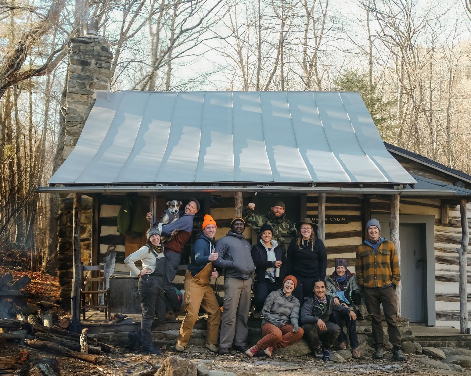 A group of hikers standing together in front of an AT cabin on a cold day.