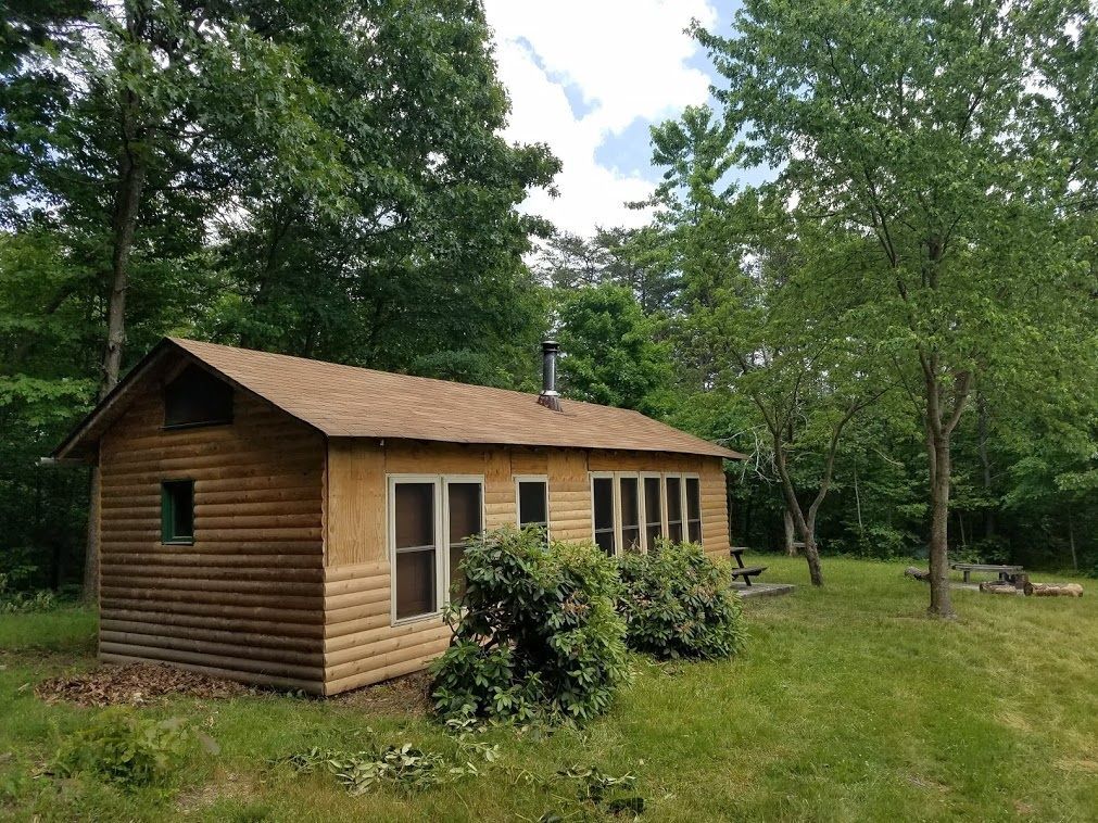 The side view of the Dawson Cabin, features two green bushes.