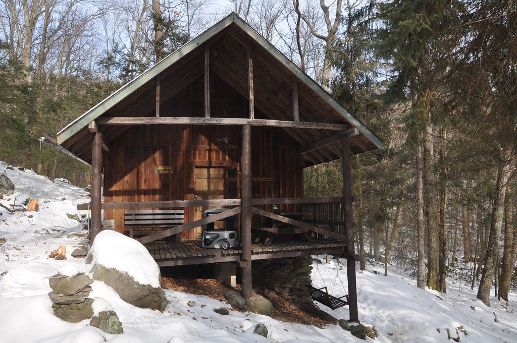 The Hermitage Cabin features a wooden front porch.