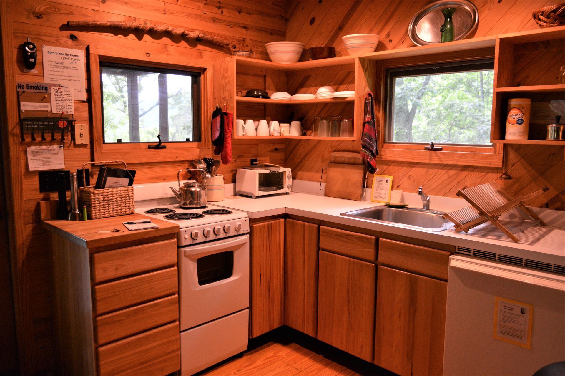 The kitchen of the Horwitz cabin showing a stovetop and oven, sink, and dishwasher.