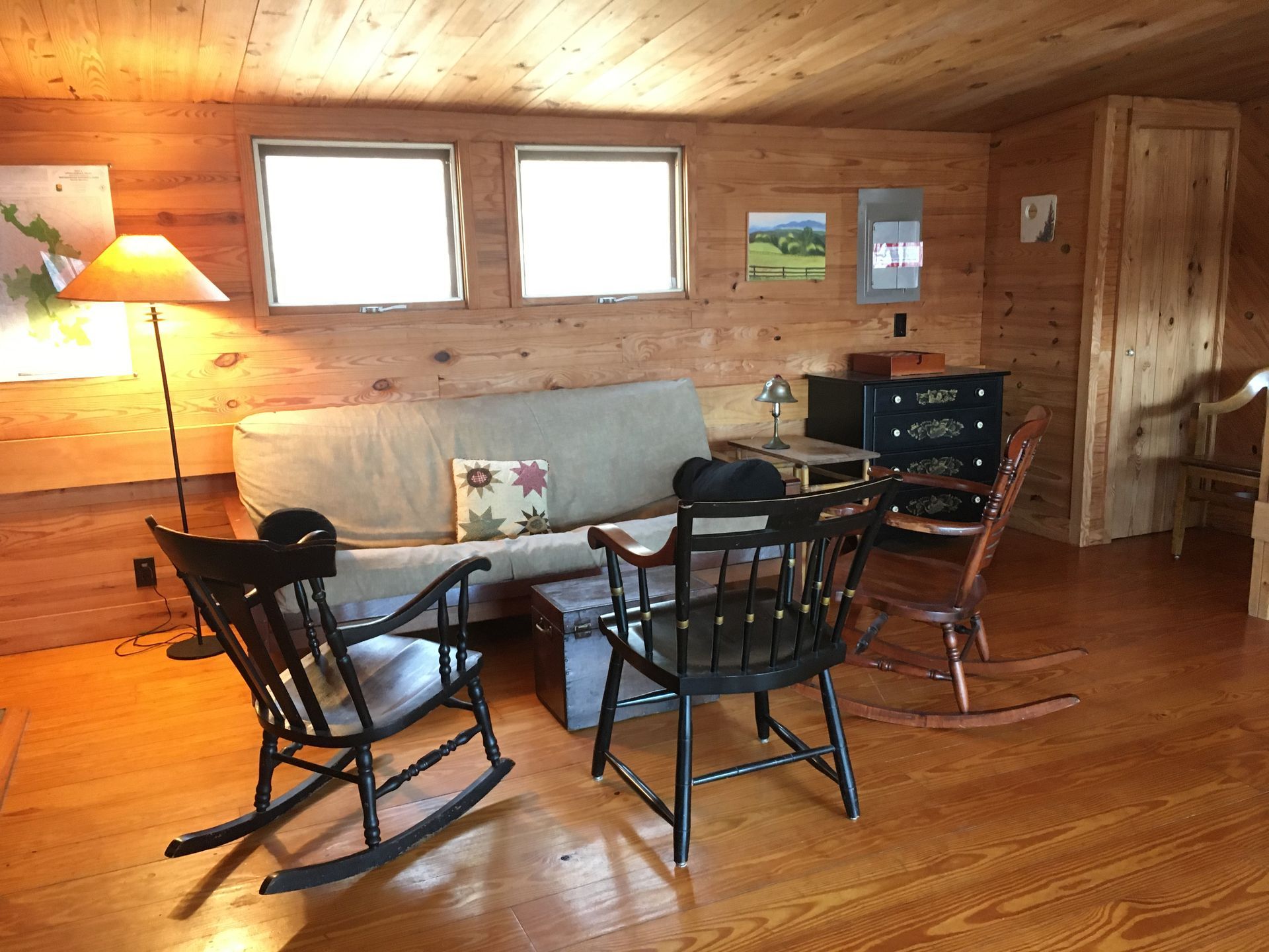 The interior of the Horwitz cabin showing a couch, a small table, and wooden chairs.