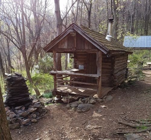 The Johnson cabin shows a small porch and chair, and accompanying firewood.