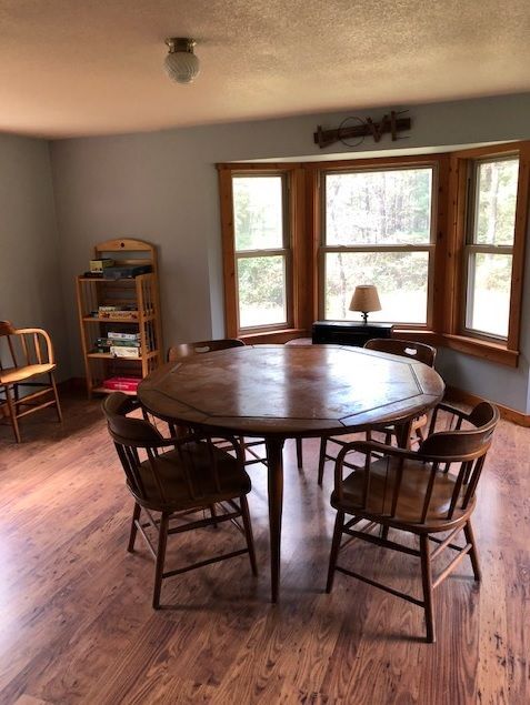 The interior view of the Lambert cabin shows a wooden table and chairs and multiple board games.