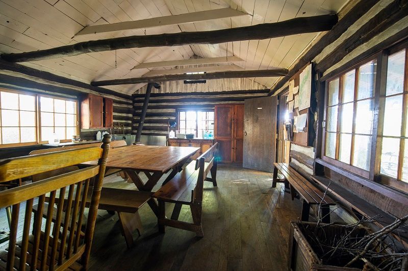 The inside of the Anna Michener cabin showing a wooden table and benches.