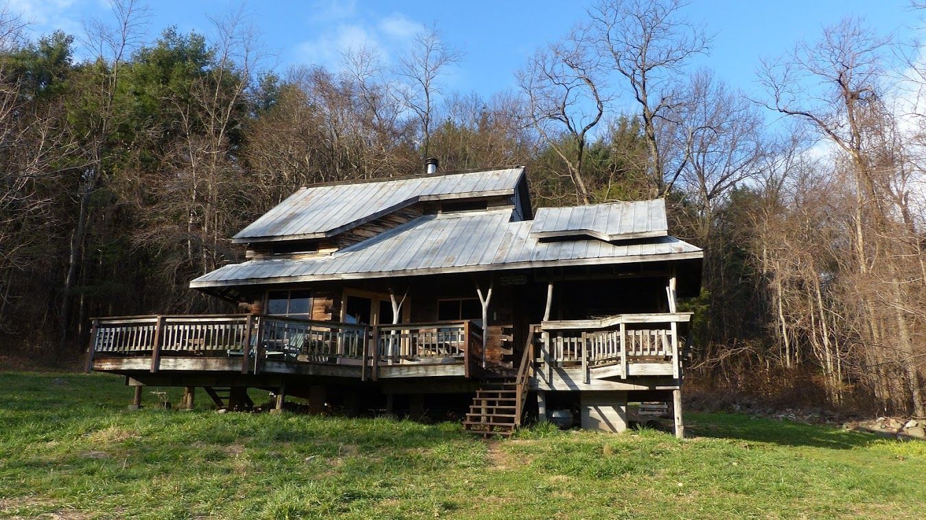 The side view of the Mutton top cabin shows a wooden staircase leading up to a wooden porch.