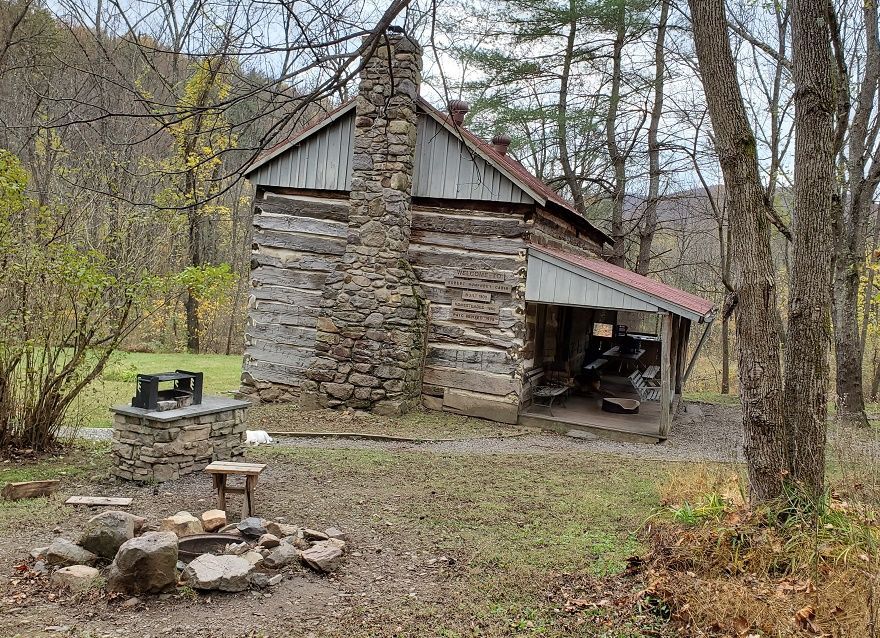 The exterior of the Robert Humphrey cabin shows an outdoor cooking area and an outdoor fireplace.