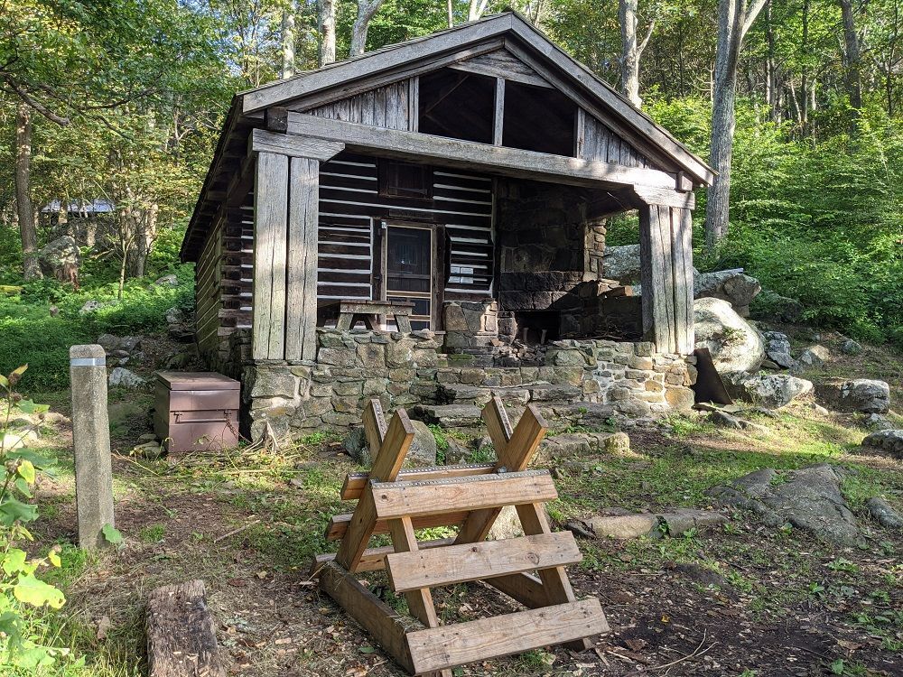 The front of the Rock Spring cabin shows a small porch and wooden picnic table.