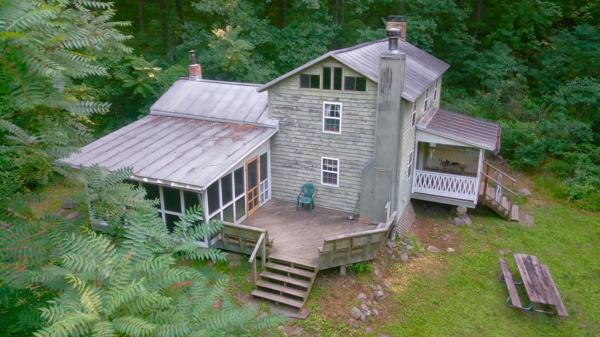 An aerial view of Rosser Lamb cabin shows a back wooden porch and a screened in seated area.
