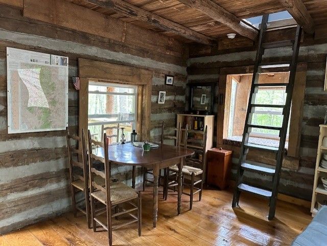 The cook-shed at Tulip Tree Cabin shows a fire pit, a wooden picnic table, and a wooden counter to cook on.