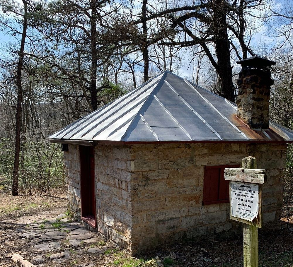 The side view of Sugar Knob cabin shows a trail sign.