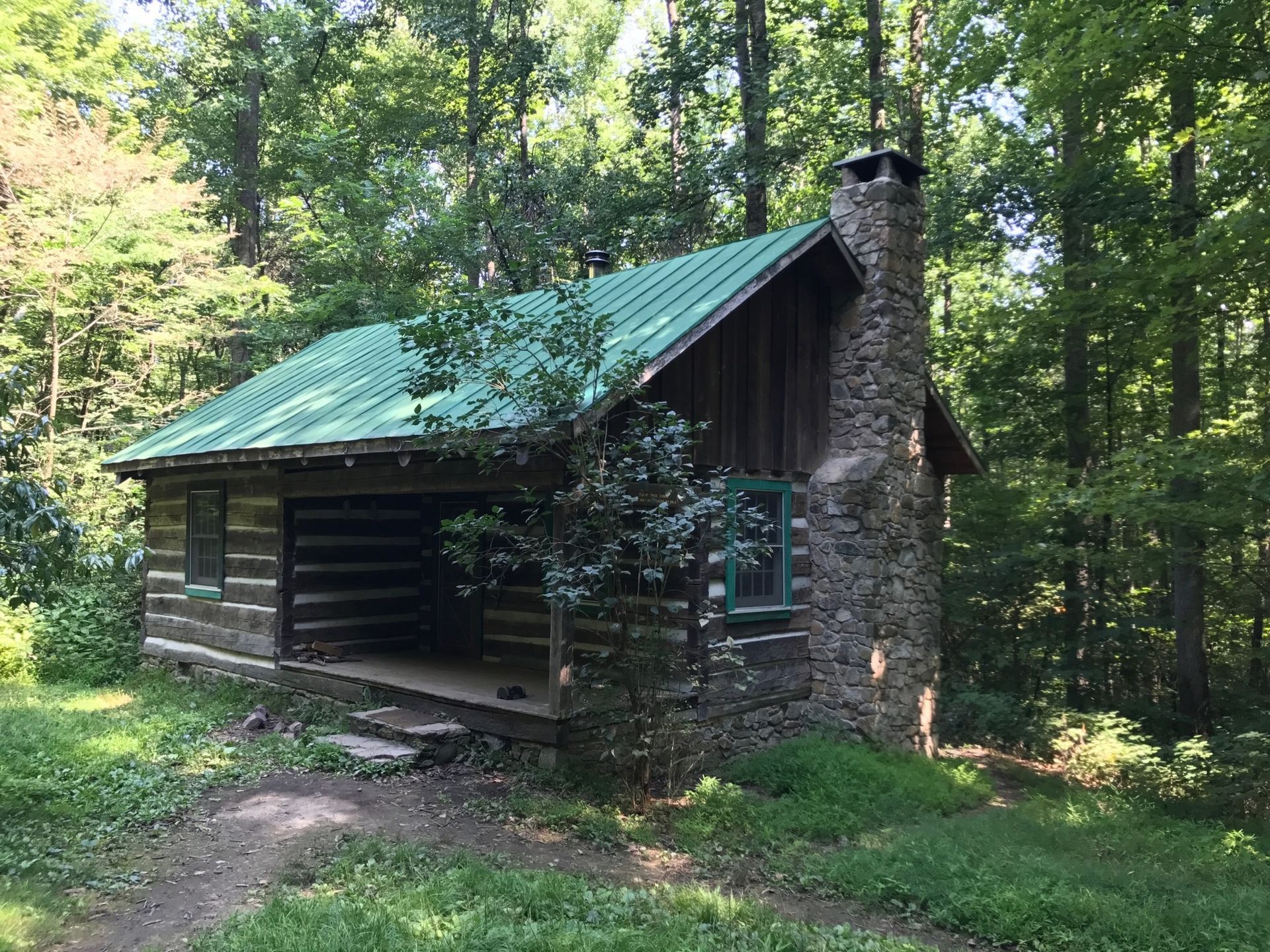 An exterior view of Tulip Tree cabin shows a small wooden porch.