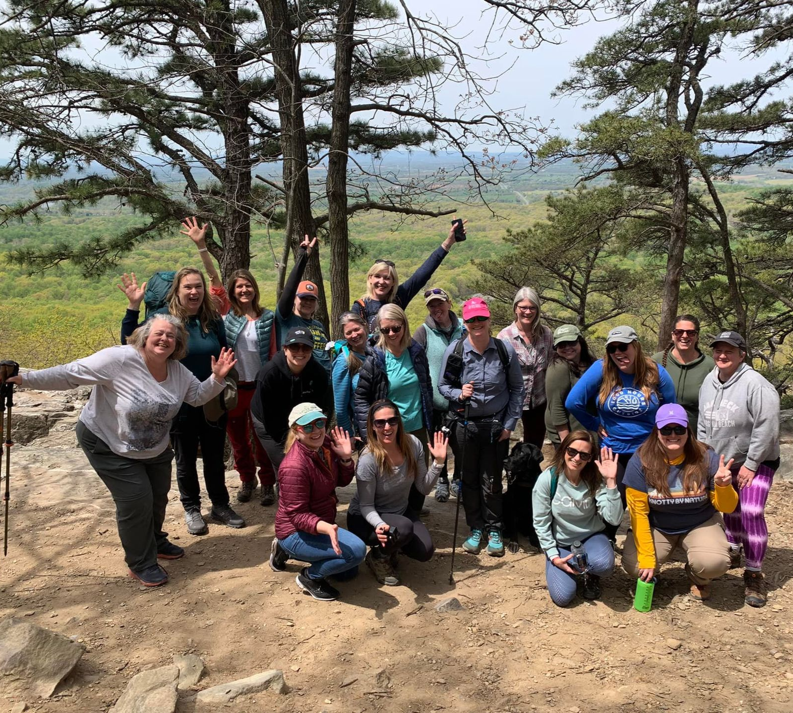 A group of women are posing for a picture on top of a mountain.