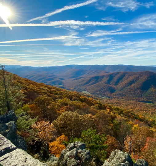 A view of a mountain range with trees and rocks on a sunny day.