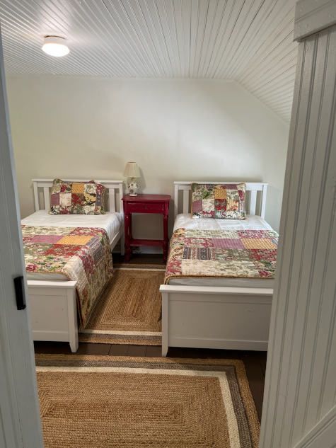 The inside of Crampton Gap cabin shows two twin beds in a room with quilts and bedding.