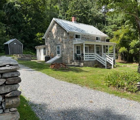 The exterior of the Crampton Gap cabin features stone-side molding and a wooden porch and stairway.