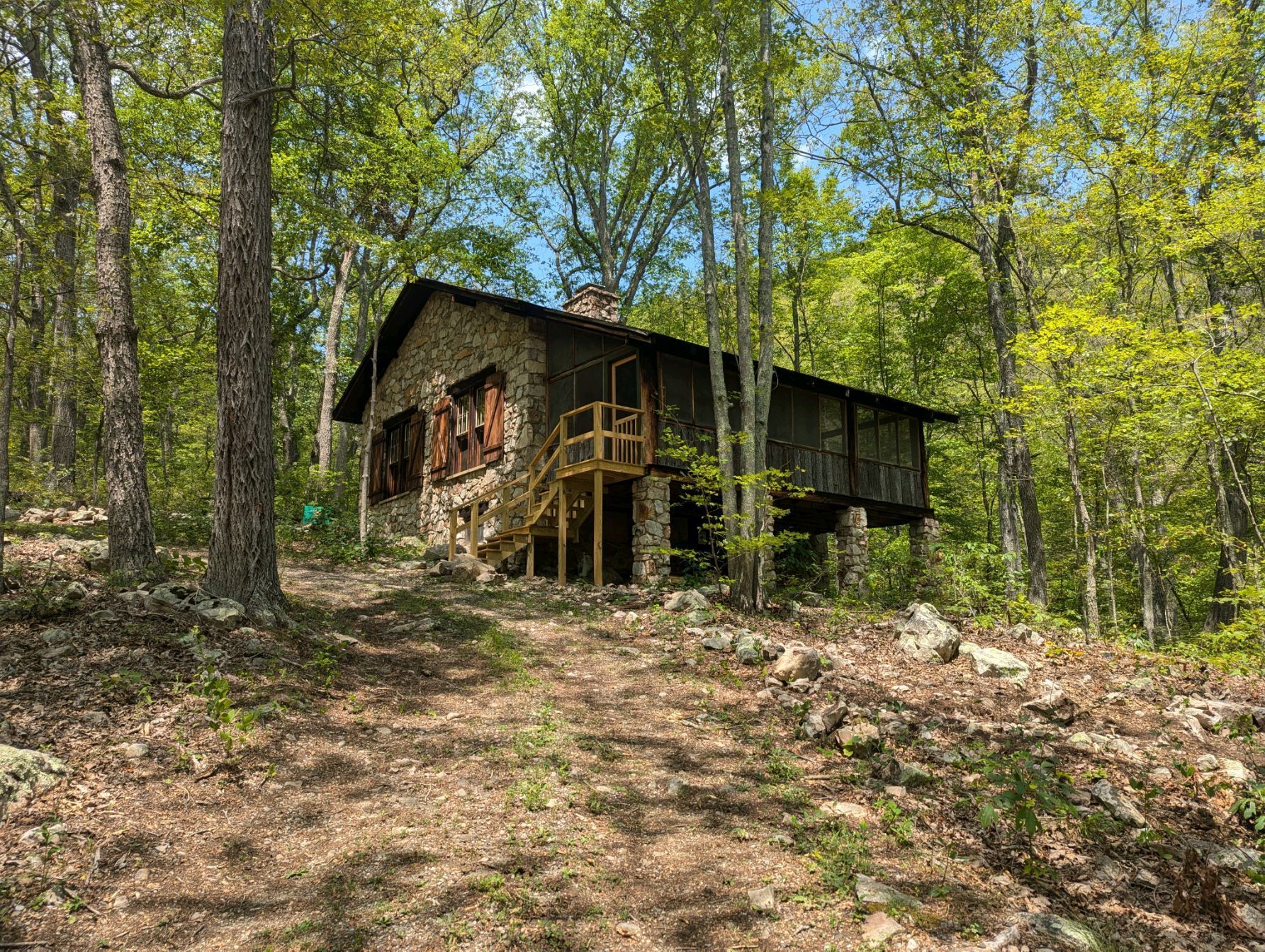 An exterior view of Fort Valley cabin shows a small wooden porch and highlights it's stone walls