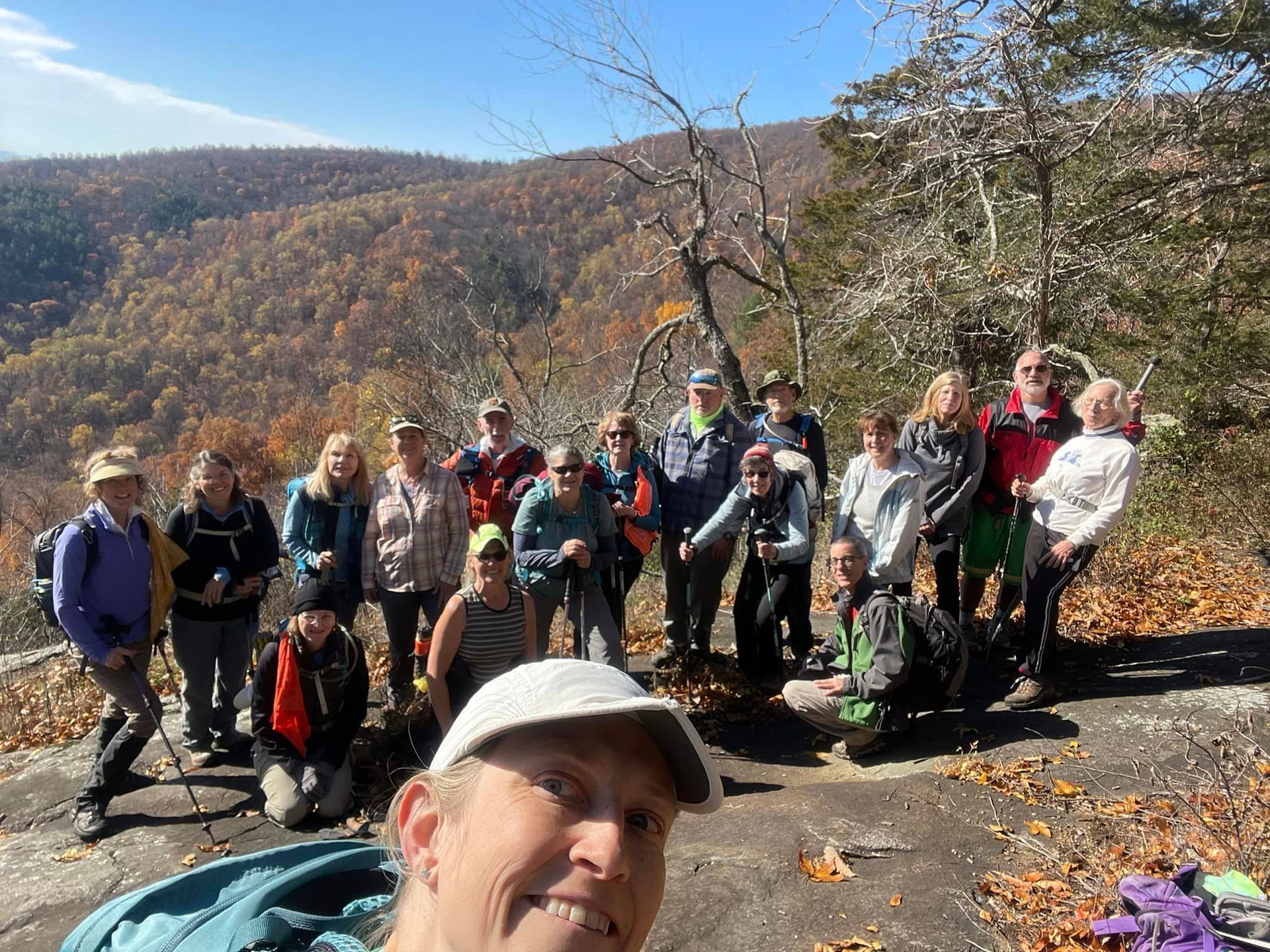 A group of people are posing for a picture on top of a mountain.