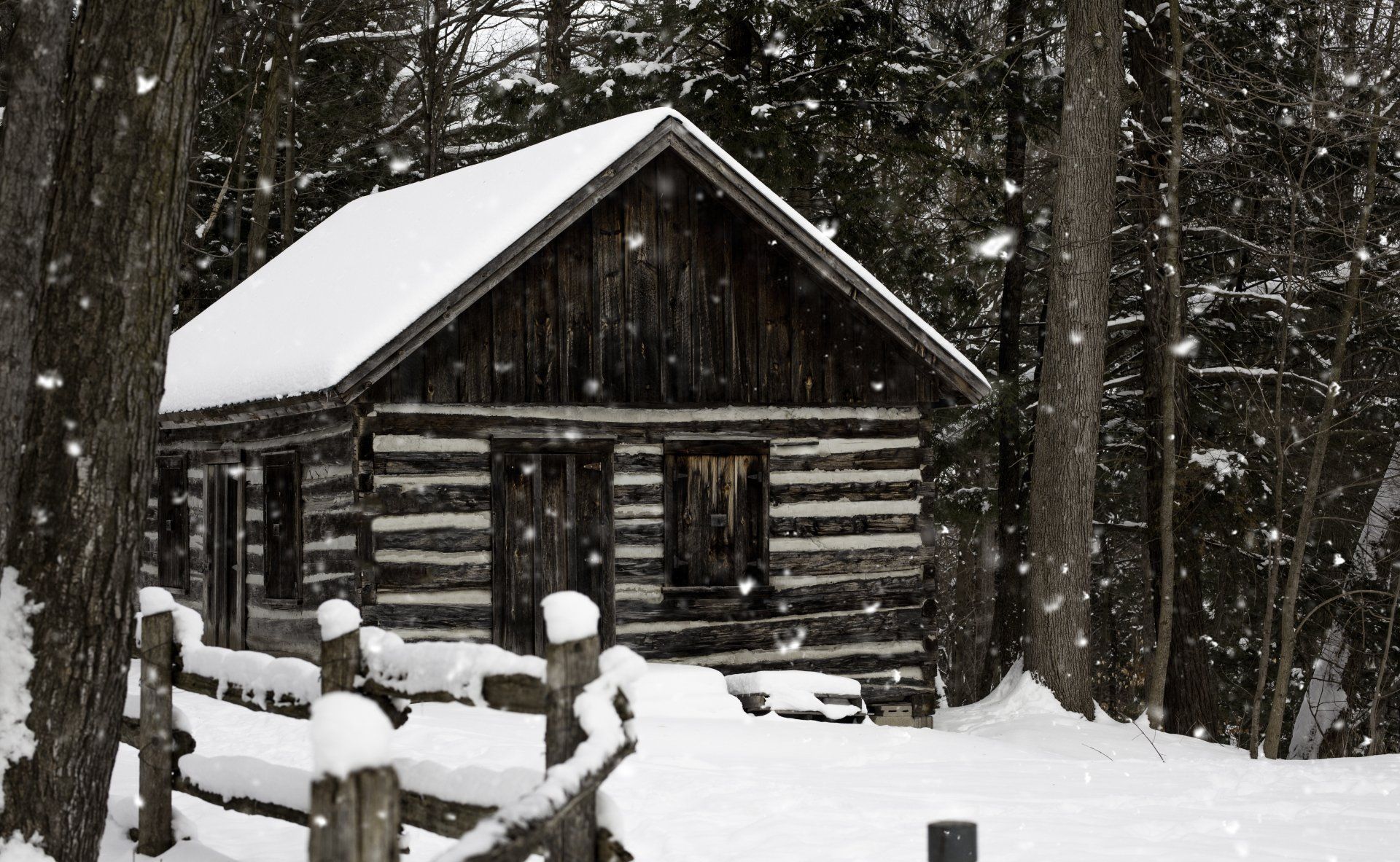 A log cabin in the middle of a snowy forest.