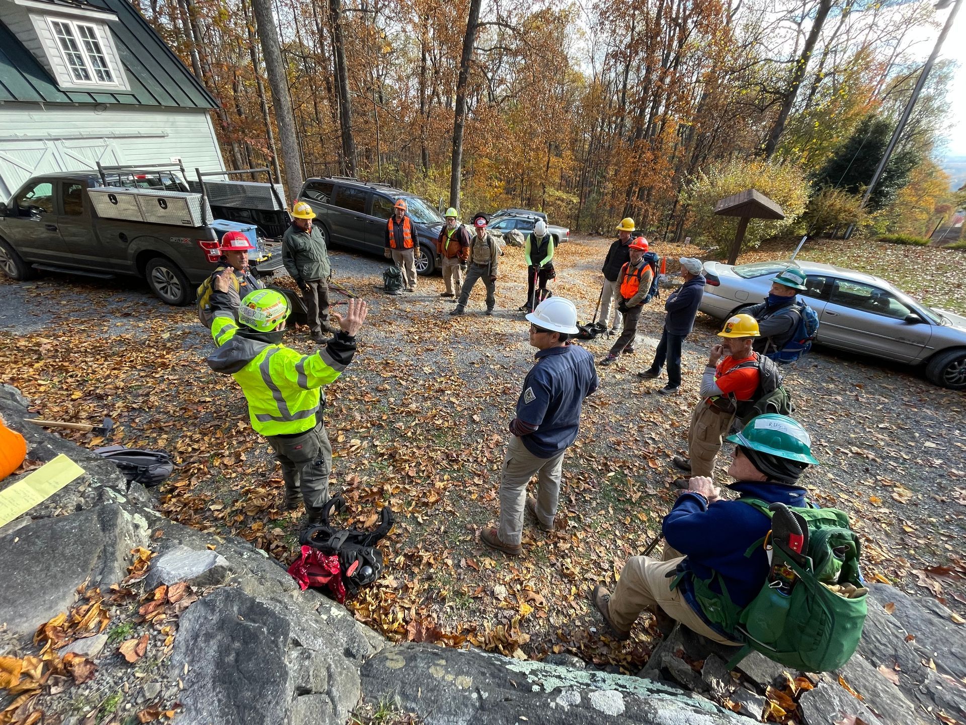 A group of Appalachian Trail volunteers, wearing hardhats having a group meeting.